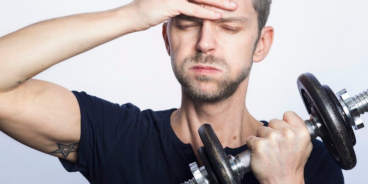 man in black crew neck t-shirt holding black dumbbell