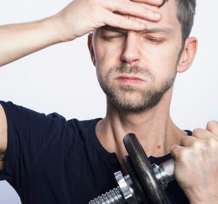 man in black crew neck t-shirt holding black dumbbell