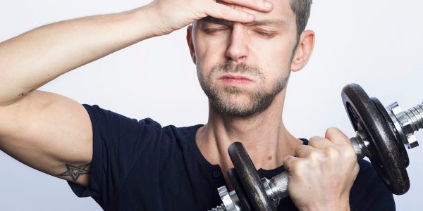 man in black crew neck t-shirt holding black dumbbell